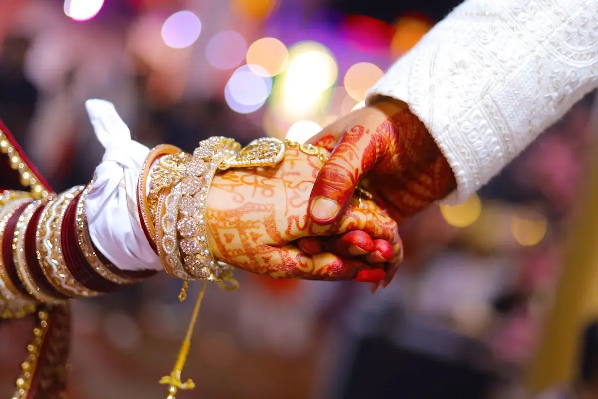 Henna-adorned hands joined during an Indian wedding ceremony